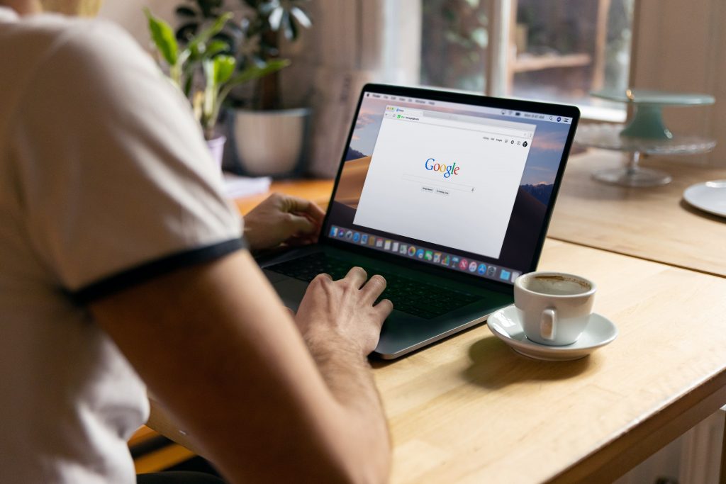 google.com on a laptop in a coffee shop